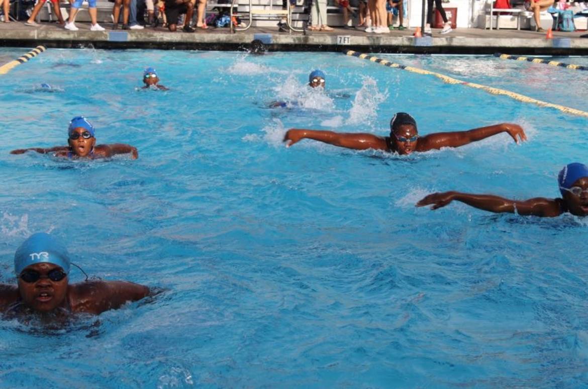 Swimmers-with-caps-competing-in-a-pool-during-a-race